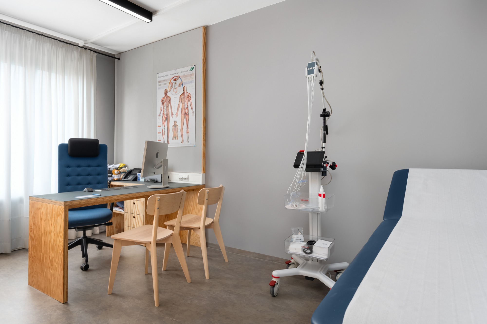 Behandlungsraum der Praxis 23 mit EKG-Gerät und Schreibtisch